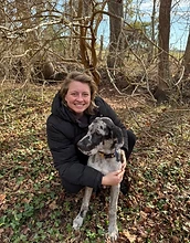 Chloe holding a goldendoodle in front of the barn