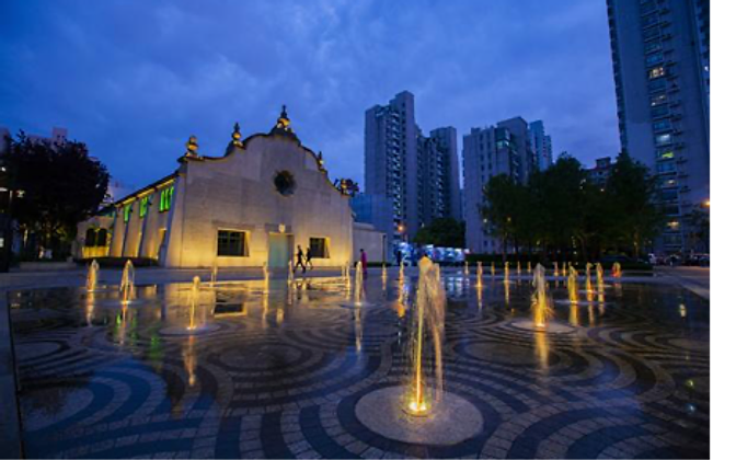 Columbia Circle after dark — an illuminated heritage building beside a lit fountain