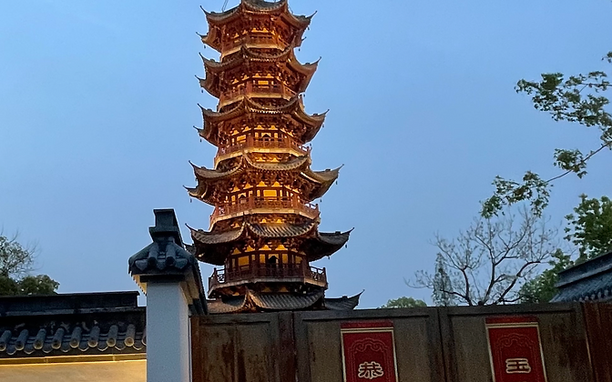 Longhua Pagoda — the illuminated wooden pagoda at dusk, framed by the temple gate