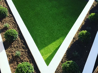 Geometric lawn framed by rendered raised beds