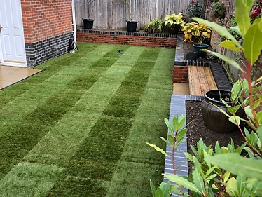 Lawn with curved brick retaining wall & built-in bench