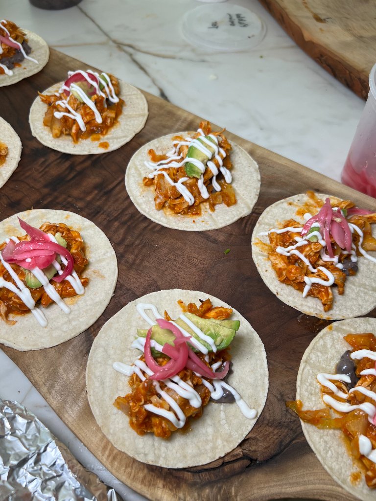 Top-down open-faced tacos with beans, crema and pickled onions