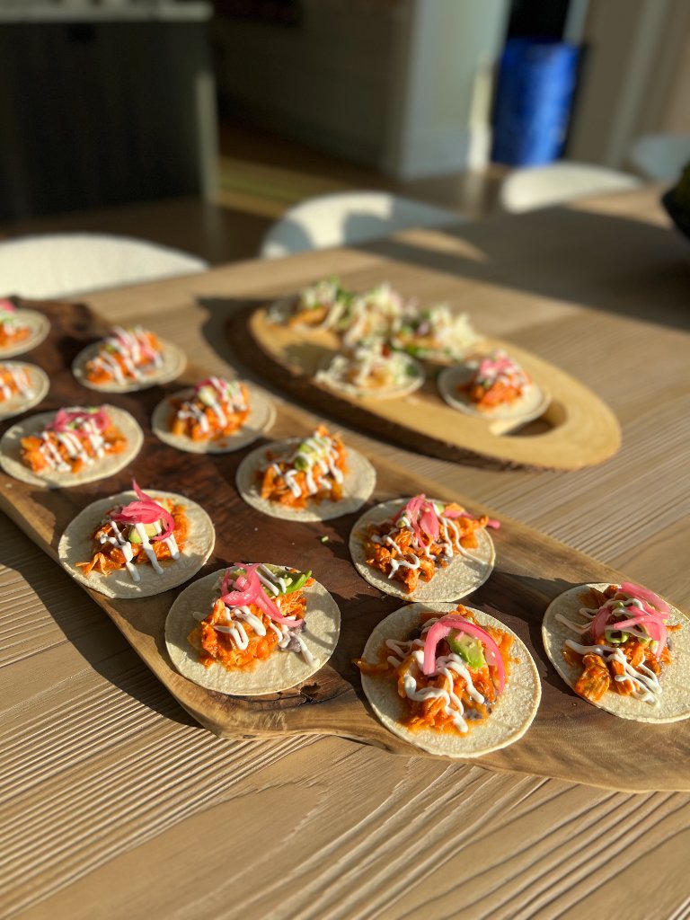 Two boards of tacos being prepped for catering service