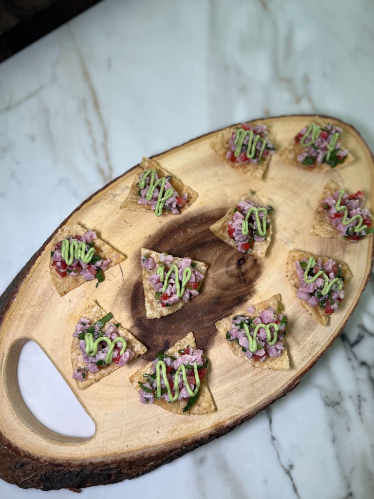 Triangular tortilla chips with salsa and green sauce on marble