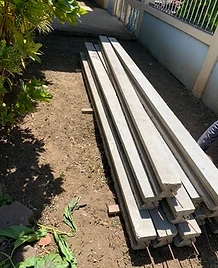 Pila de vigas y postes de concreto prefabricado con acero expuesto para muros
