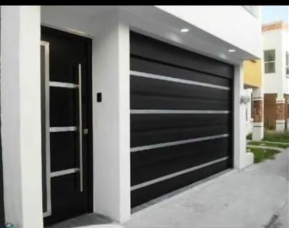 Fachada moderna con puerta de garaje negra y paredes blancas terminadas