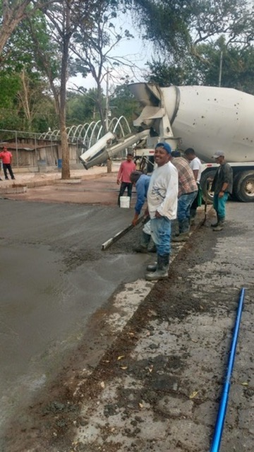 Trabajadores de JIRMAR nivelando concreto fresco en fundición de losa con camión mezclador