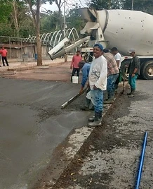 Trabajadores de JIRMAR nivelando concreto fresco en fundición de losa con camión mezclador