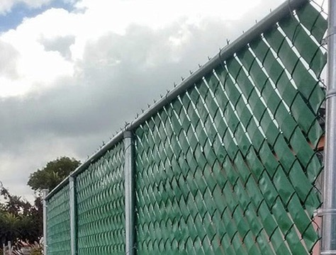 Cerca de malla galvanizada con slats de privacidad verdes instalada por JIRMAR