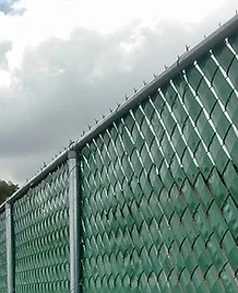 Cerca de malla galvanizada con slats de privacidad verdes instalada por JIRMAR