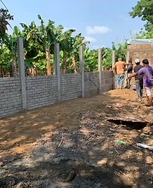 Muro perimetral en construcción con postes verticales y paneles de concreto prefabricado
