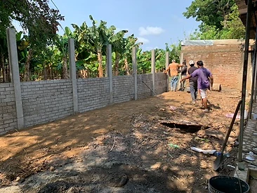 Muro perimetral en construcción con postes verticales y paneles de concreto prefabricado