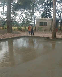 Superficie de concreto fresco recién nivelado con trabajadores supervisando el proceso