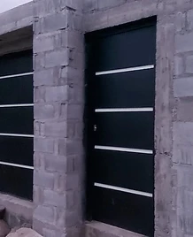 Puerta de garaje y puerta lateral instaladas en muros de bloque sin repellar