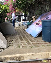 Trabajador en pasadizo de adoquines con materiales de remodelación apilados