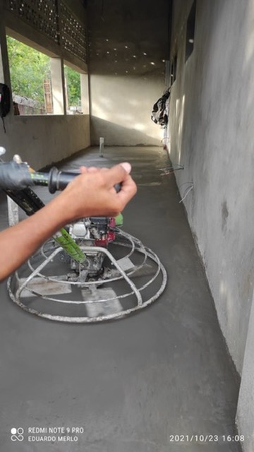 Operario de JIRMAR realizando alisado de concreto con helicóptero manual en pasillo de obra
