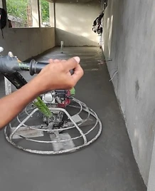 Operario de JIRMAR realizando alisado de concreto con helicóptero manual en pasillo de obra
