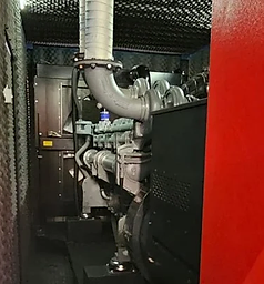 Generator engine bay with red access panel and sound-dampening lining