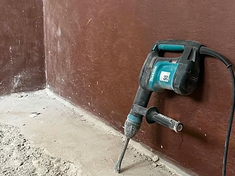 Rušenje starih talnih oblog z električnim rušilnim kladivom