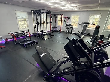 Gym interior showing leg press machine, cable crossover, and functional training rack