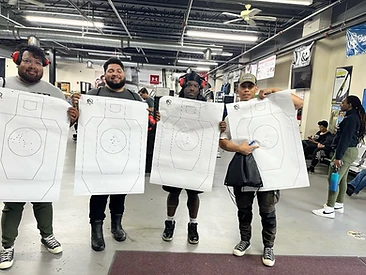 Four students holding targets after a live-fire training session