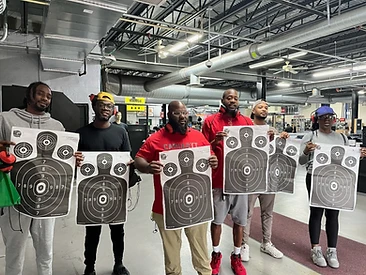 Six students posing with their targets after completing range training