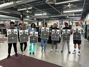 Seven students displaying their shooting targets after range training