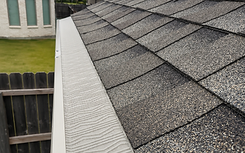 Micro-mesh gutter guard installed along a shingle roofline