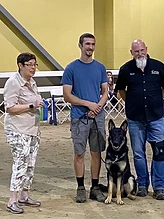 Trainer with a German Shepherd at a competition