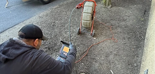 Alfieri Brothers crew member performing a sewer inspection next to the company van