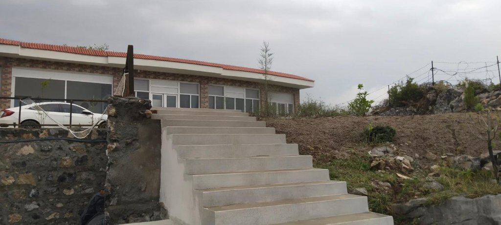 Stone-paved patio with seating at the Khanpur Dam farmhouse