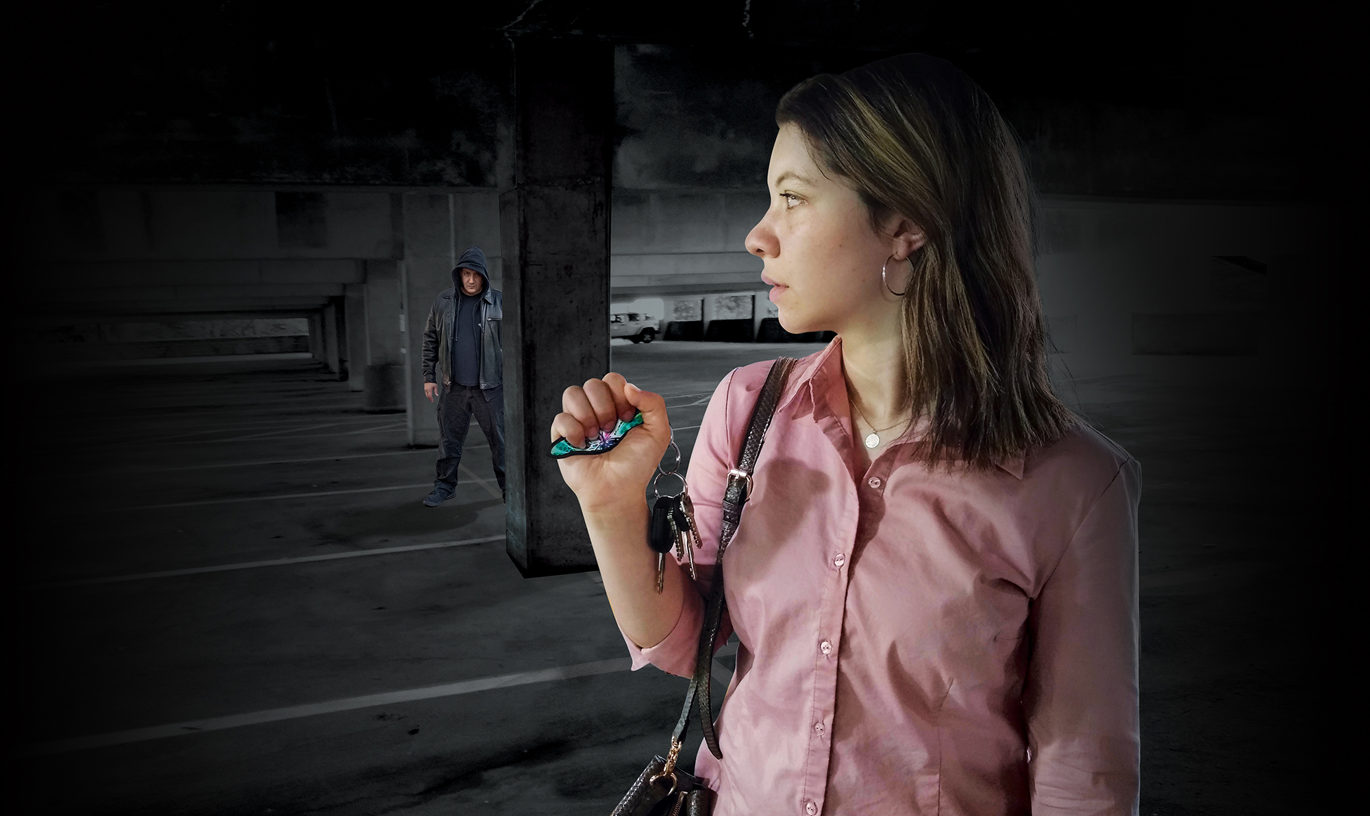 Woman holding MUNIO Self Defense keychain in a parking garage