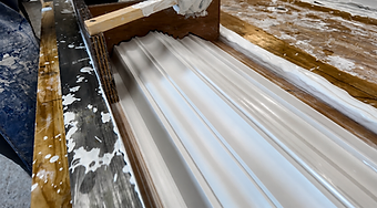 A wooden running mould drawn through wet plaster to form a cornice profile