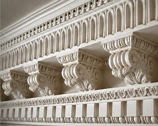 Close-up of an ornate classical plaster cornice with acanthus corbels and egg-and-dart detail