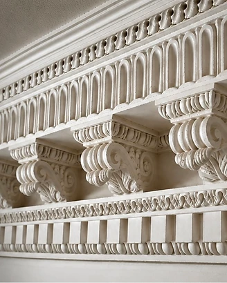 Close-up of an ornate classical plaster cornice with acanthus corbels and egg-and-dart detail