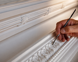 A craftsman's hand carving intricate floral plaster work