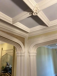 A high-angle view of the finished Neo-Gothic coffered ceiling ribs and pointed arches with a central floral boss