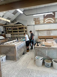 An apprentice and an experienced plasterer working side by side in the workshop