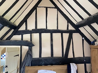 The interior gable end with exposed historic timber framing and lime plaster infill