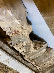 Close-up of traditional rubble stonework bedded in straw-infused lime mortar, partially opened up during the works