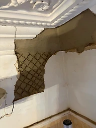 Fresh lime plaster reinstated around a damaged ceiling and wall junction