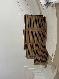 A section of failed ceiling plaster removed to reveal the timber lath substrate