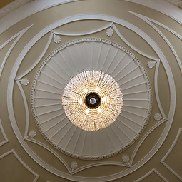 View from below of the finished central hall ceiling dome with its radiating plaster work and crystal chandelier