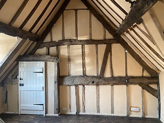 Vaulted bedroom in a Worcestershire timber-framed house with exposed elm timbers and lime-plastered infill panels