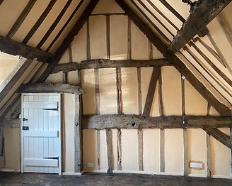 Vaulted bedroom in a Worcestershire timber-framed house with exposed elm timbers and lime-plastered infill panels