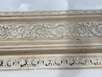 Front-facing view of the stripped Victorian cornice with a jagged vertical crack running through the acanthus frieze