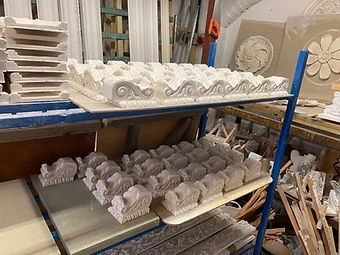Rows of cast acanthus console brackets drying on the workshop racks