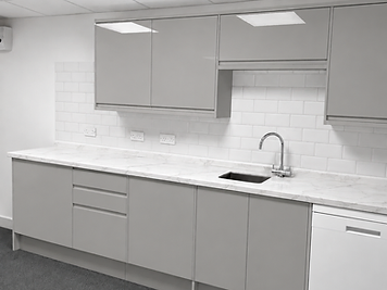 Modern kitchenette with gloss units, marble worktop and integrated appliances