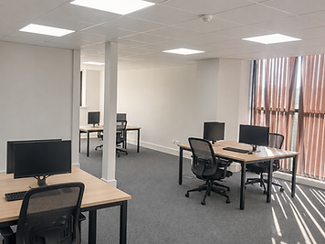 Open-plan workspace with natural light and oak-finish desks