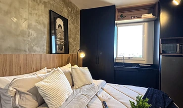 Estúdio mobiliado com cama e cozinha integrada